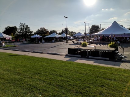 Susan G. Komen Race for the Cure Fundraiser - Multiple Tents on Asphalt (10' x 10', 20' x 20', 20' x 40', 40' x 40'), Stage, Rectangular Tables, Wooden Chairs.