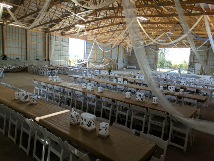 Rustic Barn Wedding Reception - Rectangular Tables, White Padded Chairs.